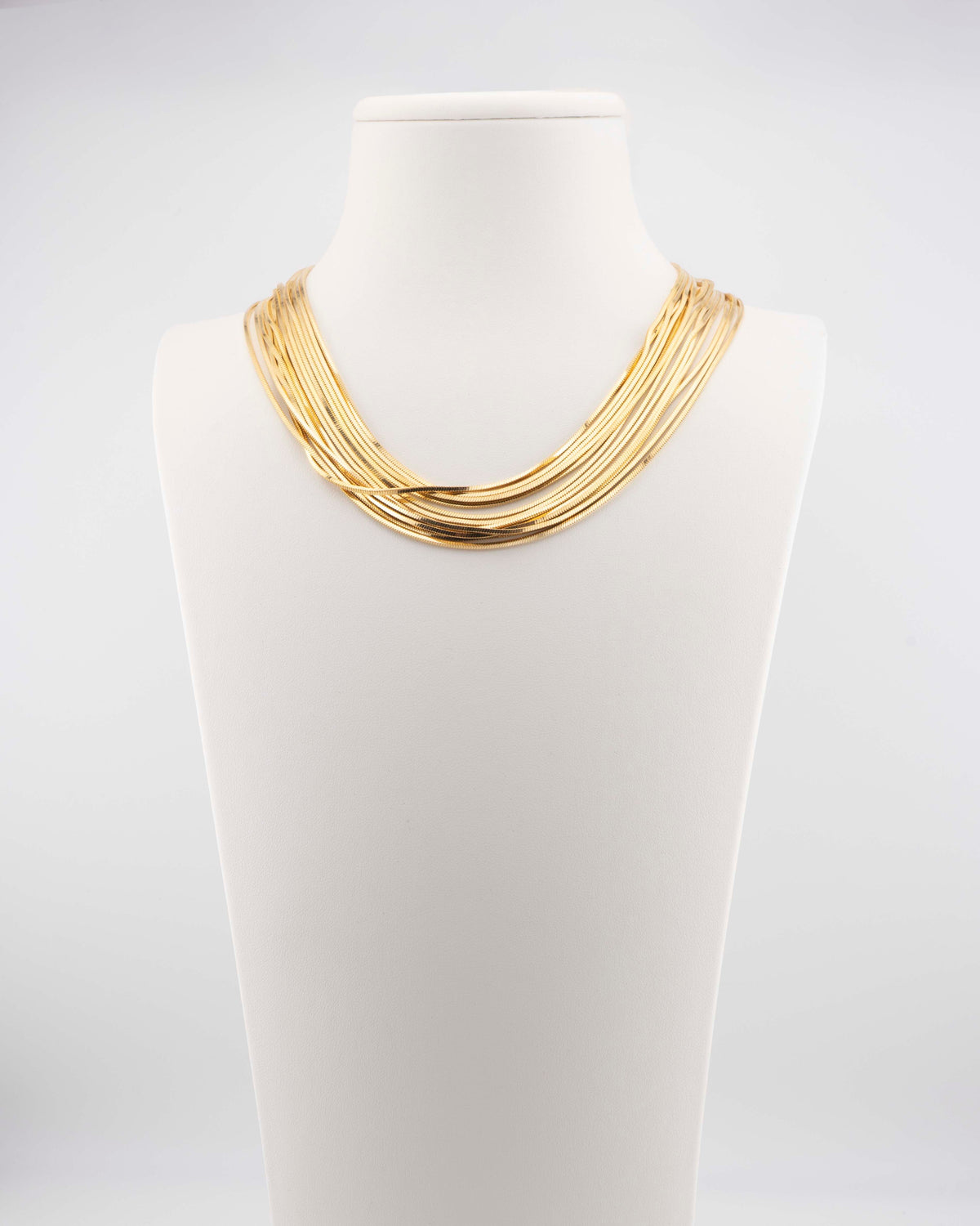 Collana girocollo con fili di catena a scalare in bronzo placcato oro 18 carati. Gioiello artigianale italiano dal design luminoso ed elegante firmato Marri Cortona