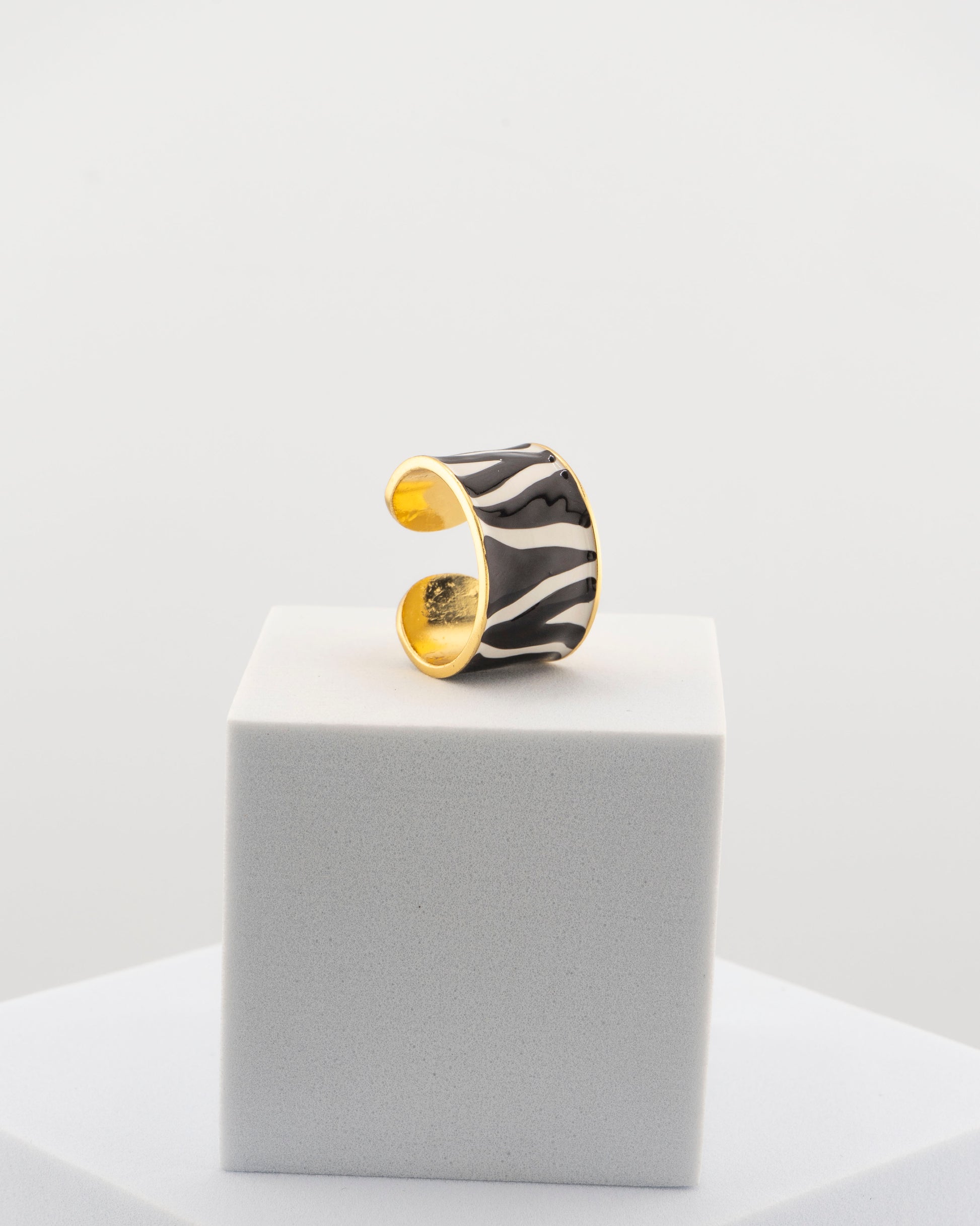 Handcrafted ring in 18K gold-plated bronze with black and white zebra-patterned smalto.
Born from an original Marri Cortona design, made by hand in Tuscany.