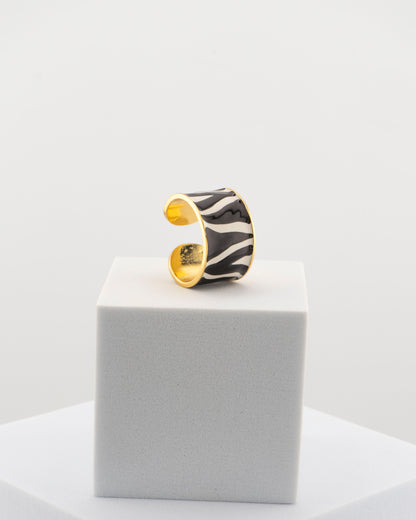 Handcrafted ring in 18K gold-plated bronze with black and white zebra-patterned smalto.
Born from an original Marri Cortona design, made by hand in Tuscany.