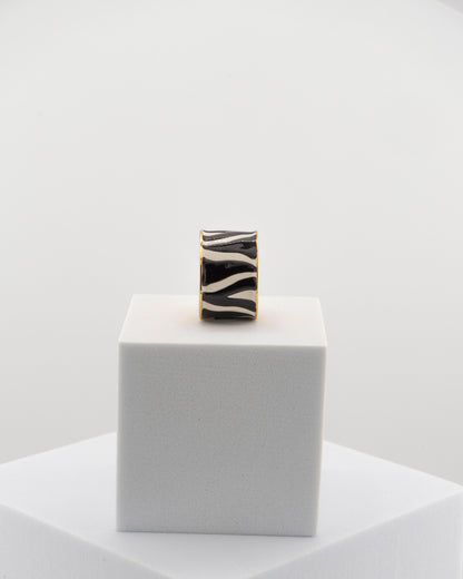 Handcrafted ring in 18K gold-plated bronze with black and white zebra-patterned smalto.
Born from an original Marri Cortona design, made by hand in Tuscany.
