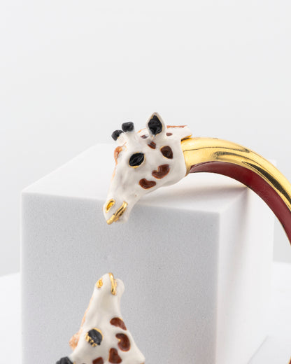 Open bracelet in white bronze with 18K gold plating and hand-painted giraffe heads.
An original Marri Cortona design — handmade in Tuscany.