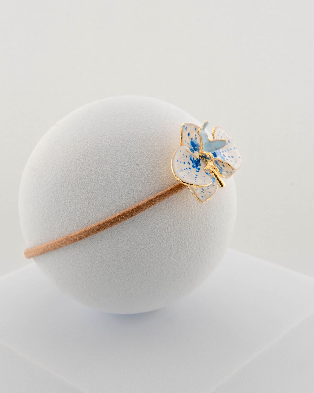 Handcrafted bracelet with adjustable cord and orchid pendant in 18K gold-plated bronze.
Each piece is hand-painted with enamel in Tuscany — unique and unrepeatable.