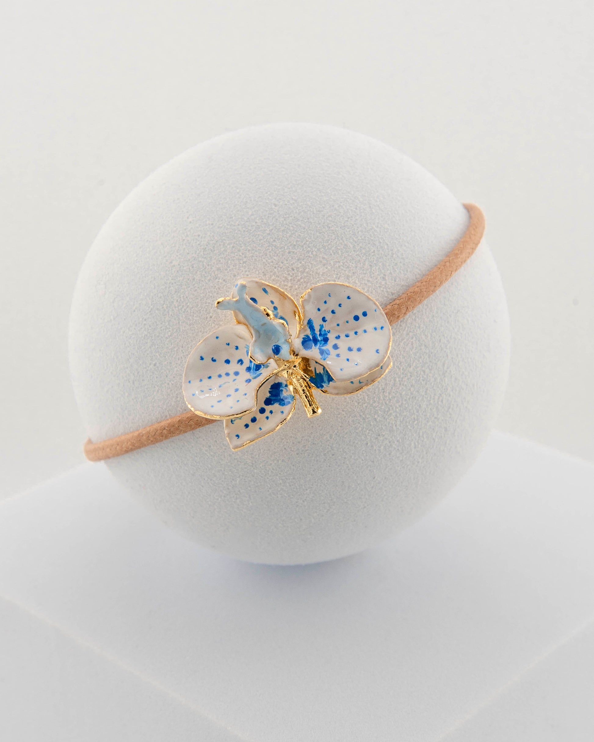 Handcrafted bracelet with adjustable cord and orchid pendant in 18K gold-plated bronze.
Each piece is hand-painted with enamel in Tuscany — unique and unrepeatable.