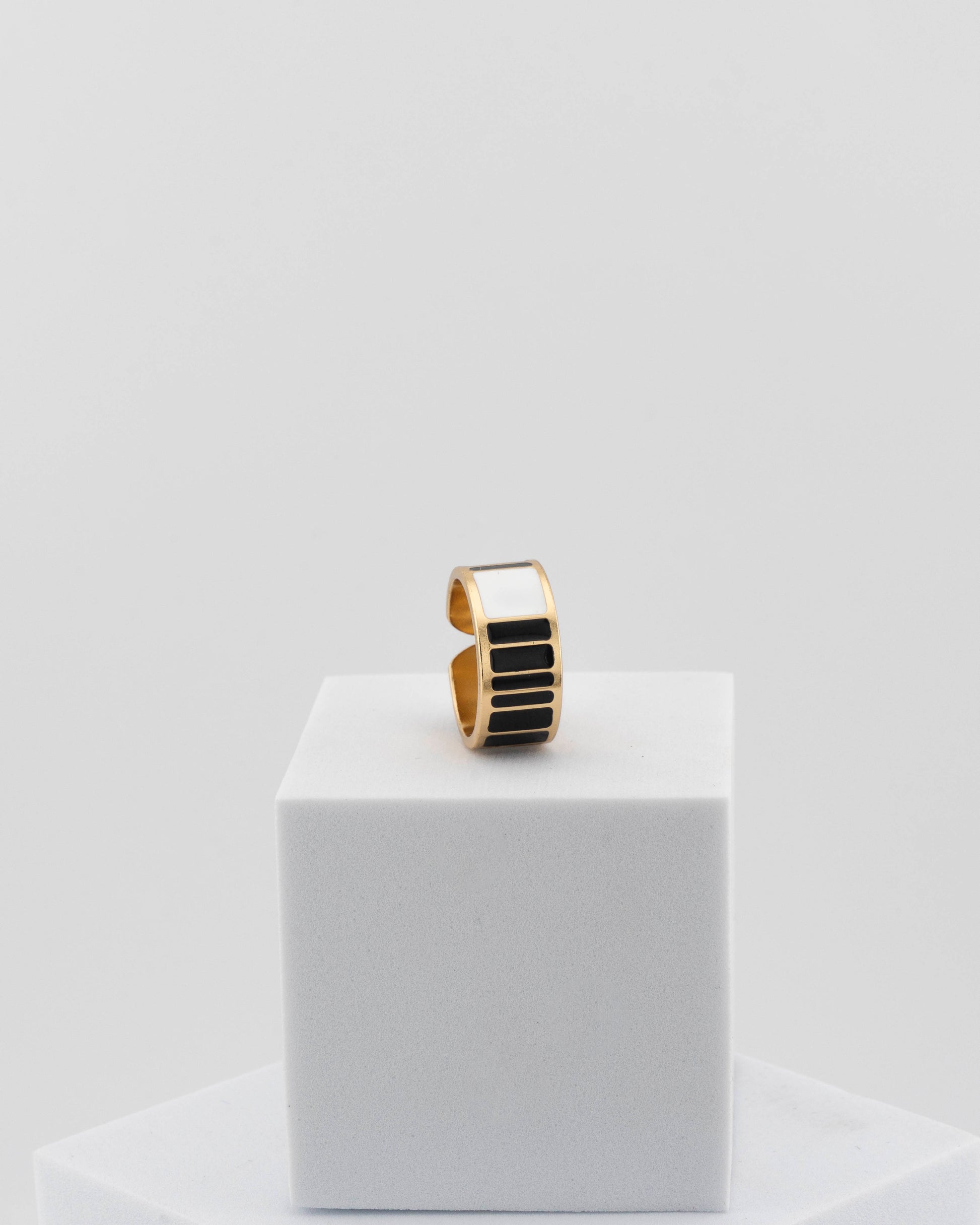 Adjustable enamel ring in 18K gold-plated bronze with black & white finish.
Handcrafted in Tuscany — pure light and timeless design.