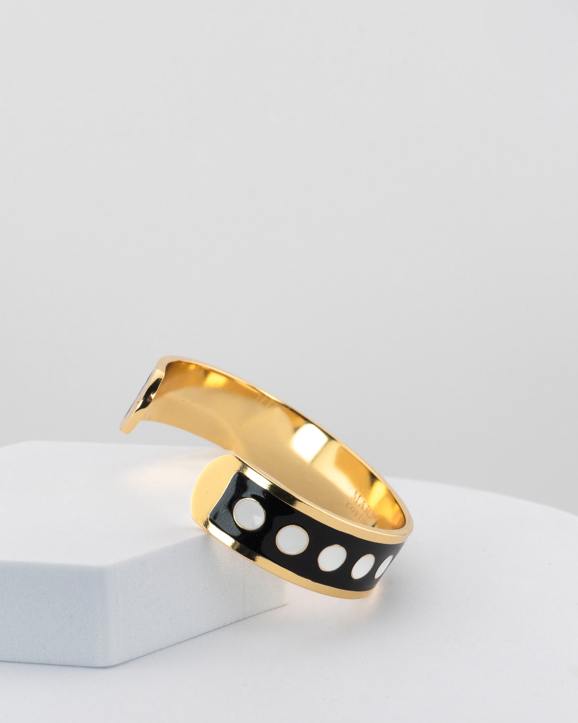 Adjustable bangle in 18K gold-plated bronze with black & white enamel.
Handcrafted in Tuscany — bold lines, timeless elegance.