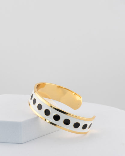 Adjustable bangle in 18K gold-plated bronze with black & white enamel.
Handcrafted in Tuscany — bold lines, timeless elegance.