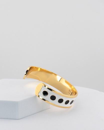 Adjustable bangle in 18K gold-plated bronze with black & white enamel.
Handcrafted in Tuscany — bold lines, timeless elegance.