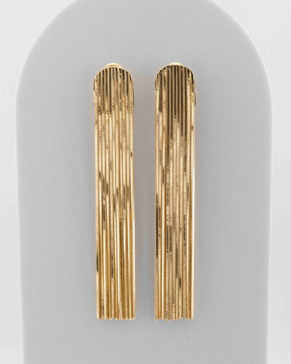 Handcrafted in Tuscany, the MarriCortona Voilà Earrings in bronze 18k gold plated feature 10 cm golden fringes — luminous, elegant, and timelessly Italian.