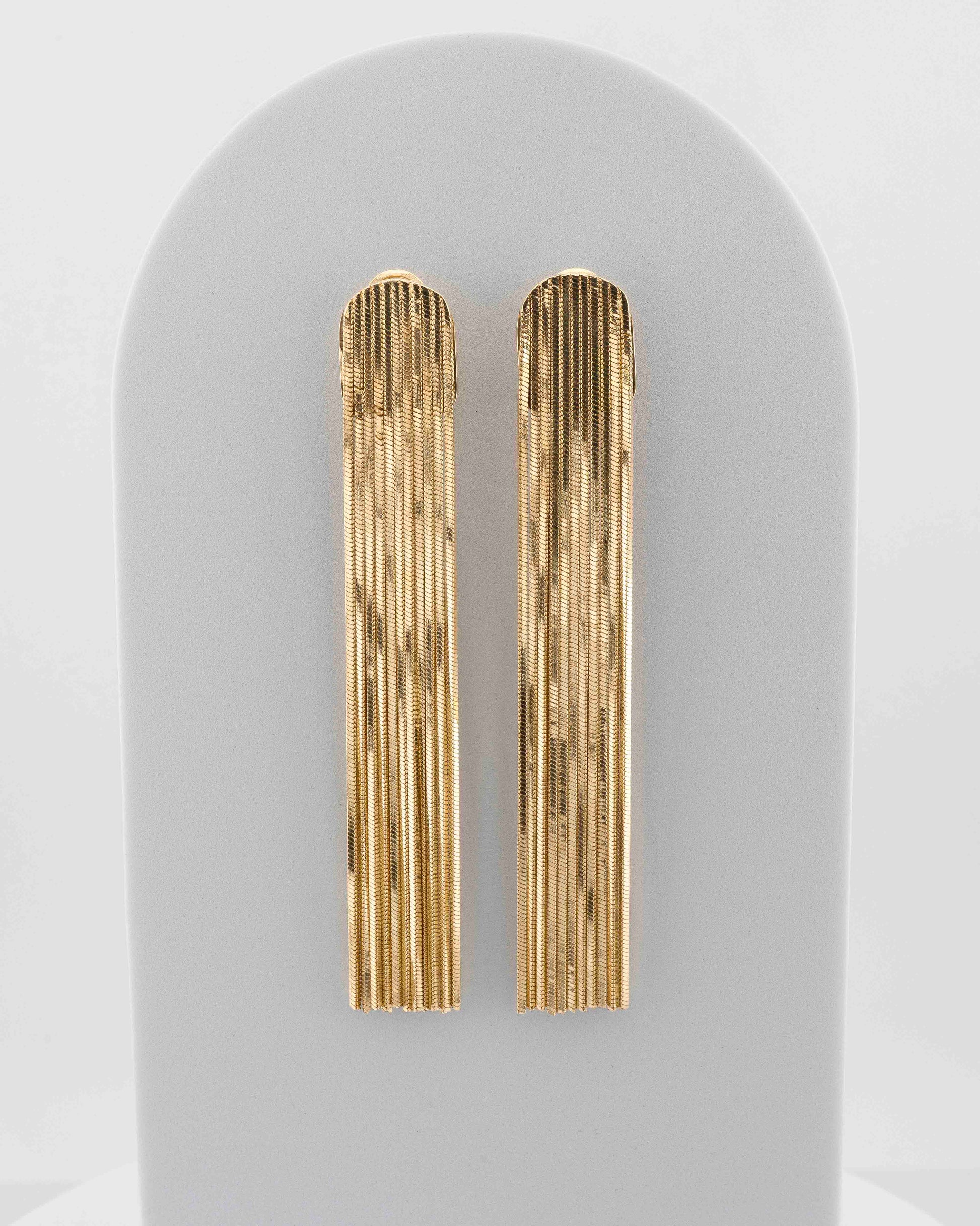 Handcrafted in Tuscany, the MarriCortona Voilà Earrings in bronze 18k gold plated feature 10 cm golden fringes — luminous, elegant, and timelessly Italian.