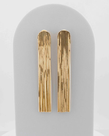 Handcrafted in Tuscany, the MarriCortona Voilà Earrings in bronze 18k gold plated feature 10 cm golden fringes — luminous, elegant, and timelessly Italian.
