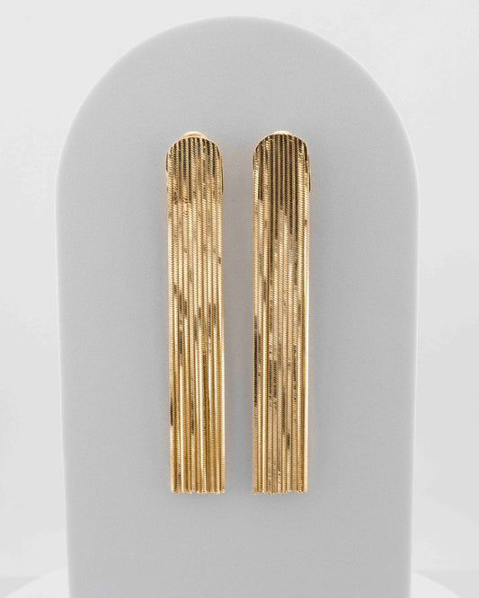 Handcrafted in Tuscany, the MarriCortona Voilà Earrings in bronze 18k gold plated feature 10 cm golden fringes — luminous, elegant, and timelessly Italian.