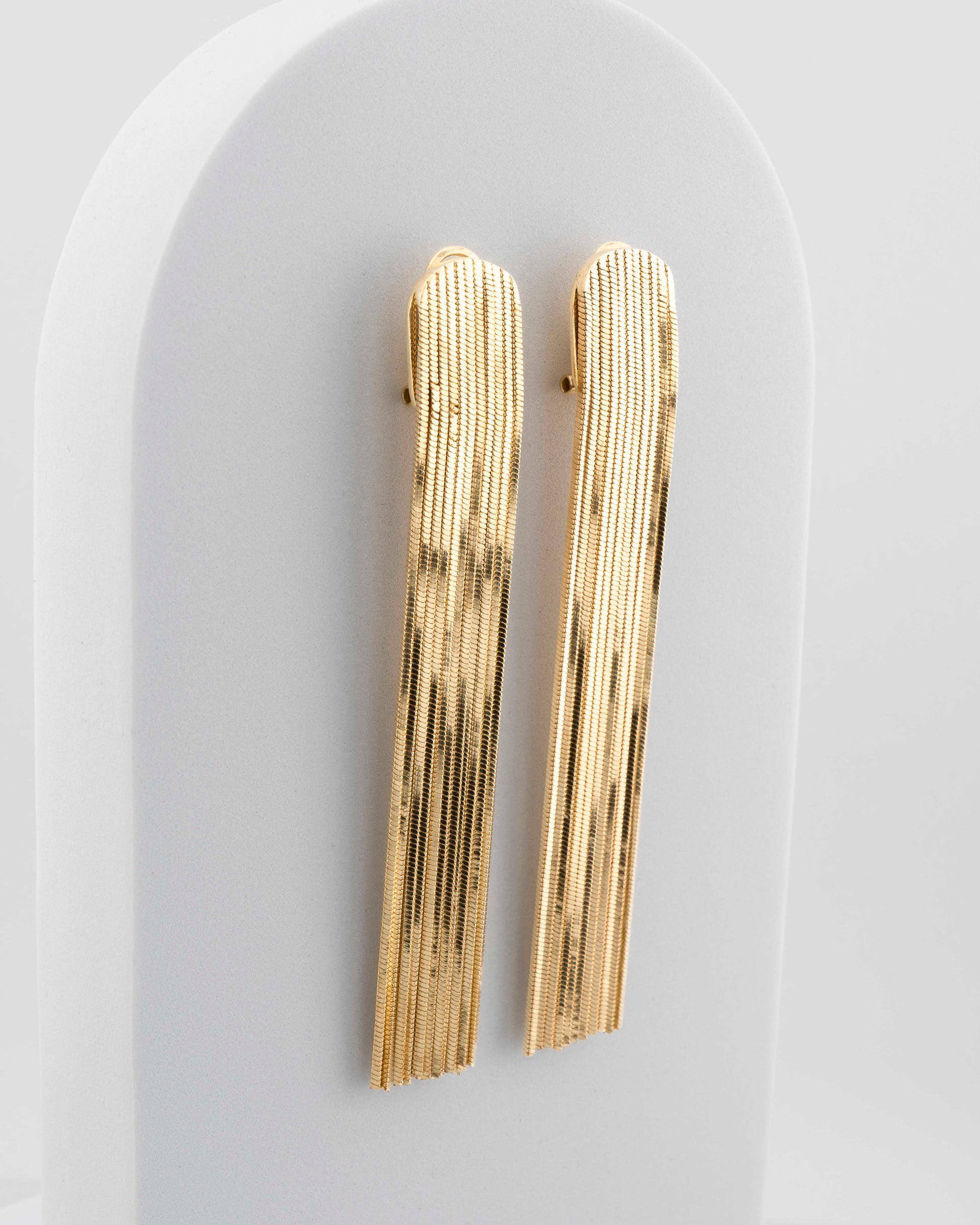 Handcrafted in Tuscany, the MarriCortona Voilà Earrings in bronze 18k gold plated feature 10 cm golden fringes — luminous, elegant, and timelessly Italian.
