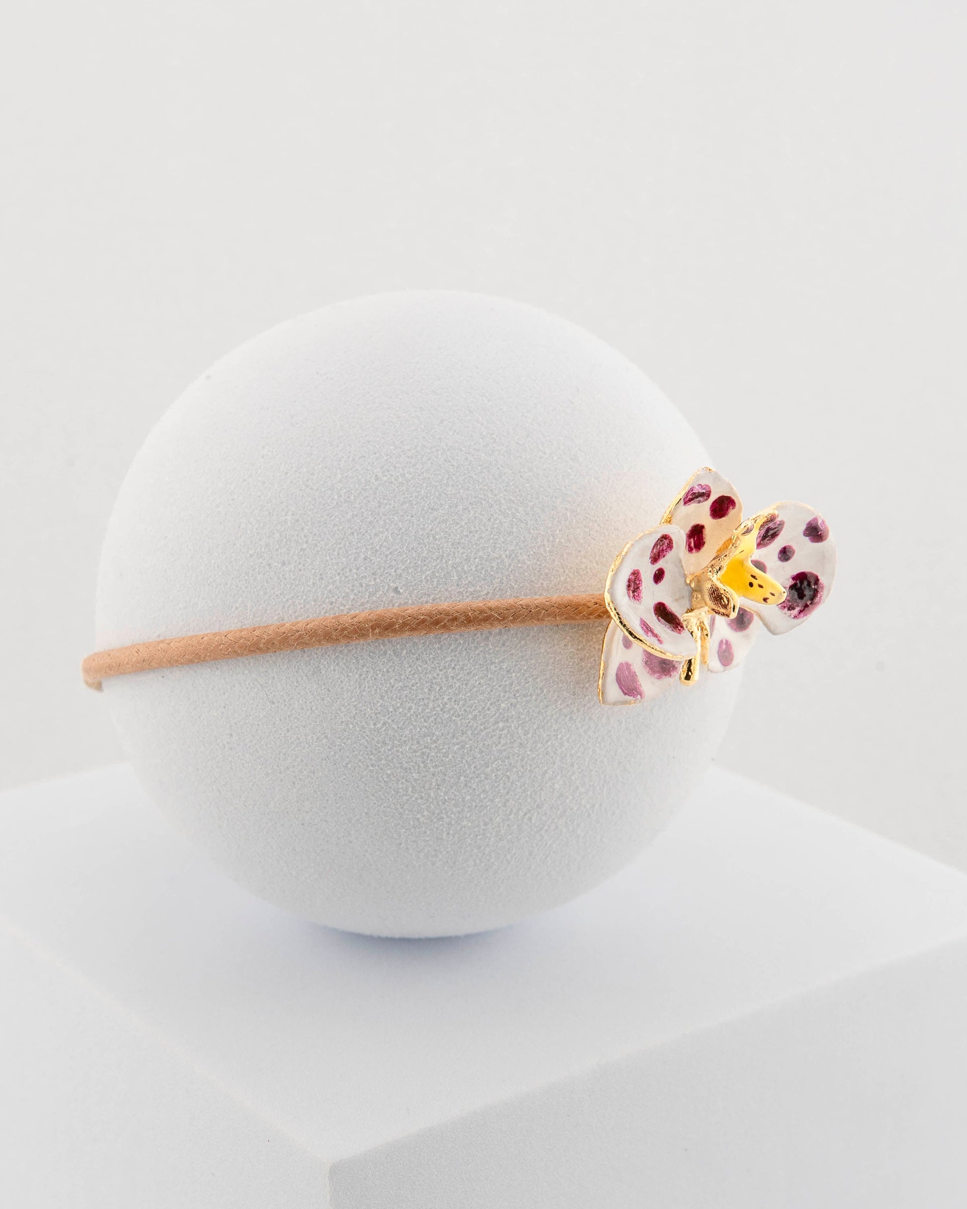 Handcrafted bracelet with adjustable cord and orchid pendant in 18K gold-plated bronze.
Each piece is hand-painted with enamel in Tuscany — unique and unrepeatable.