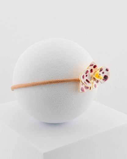 Handcrafted bracelet with adjustable cord and orchid pendant in 18K gold-plated bronze.
Each piece is hand-painted with enamel in Tuscany — unique and unrepeatable.