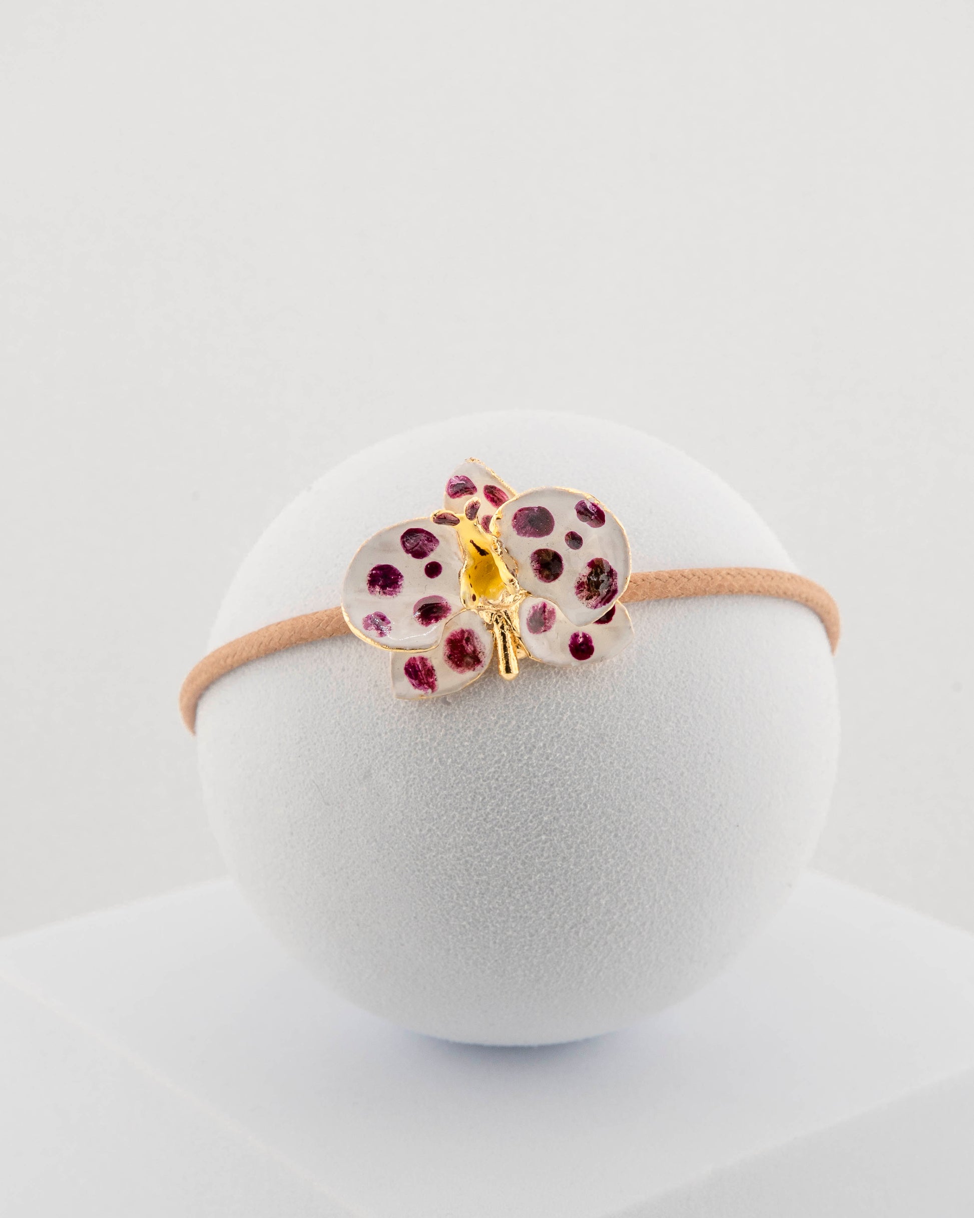 Handcrafted bracelet with adjustable cord and orchid pendant in 18K gold-plated bronze.
Each piece is hand-painted with enamel in Tuscany — unique and unrepeatable.