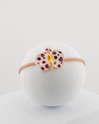 Handcrafted bracelet with adjustable cord and orchid pendant in 18K gold-plated bronze.
Each piece is hand-painted with enamel in Tuscany — unique and unrepeatable.