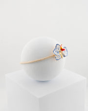 Handcrafted bracelet with adjustable cord and orchid pendant in 18K gold-plated bronze.
Each piece is hand-painted with enamel in Tuscany — unique and unrepeatable.