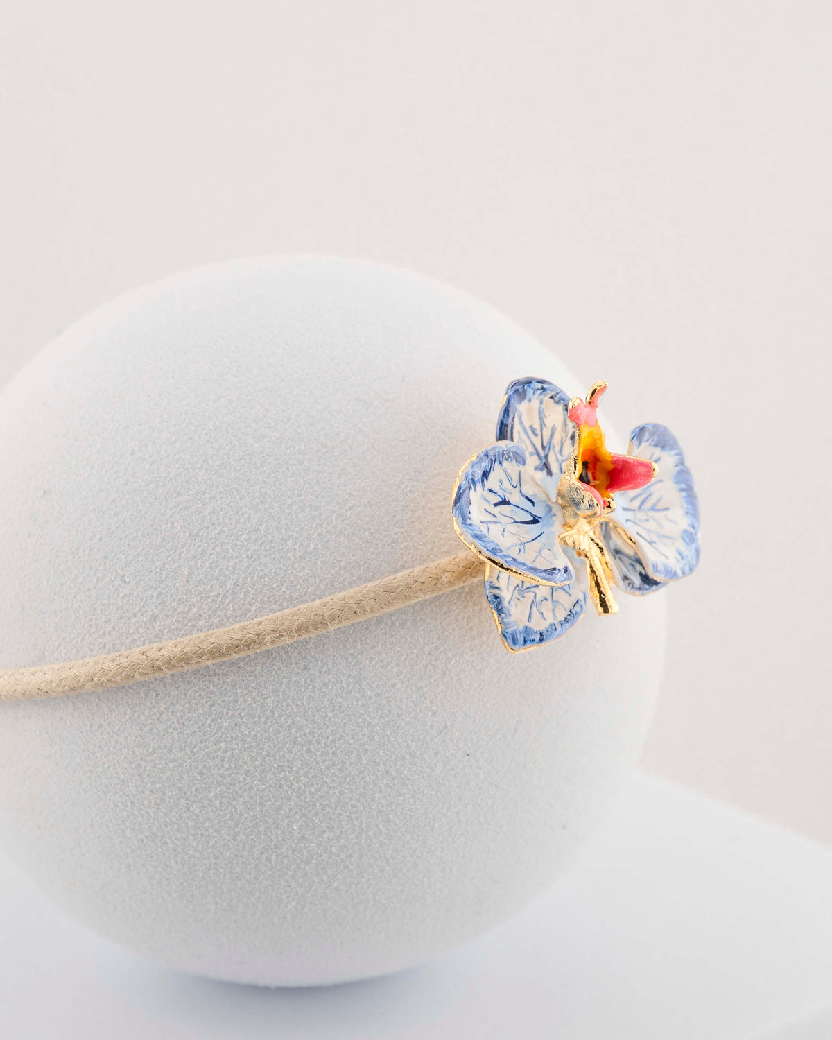 Handcrafted bracelet with adjustable cord and orchid pendant in 18K gold-plated bronze.
Each piece is hand-painted with enamel in Tuscany — unique and unrepeatable.