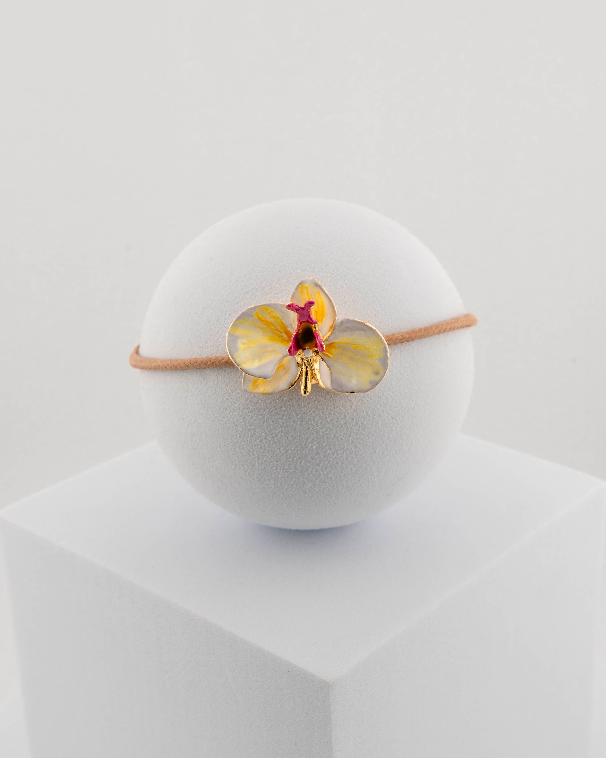 Handcrafted bracelet with adjustable cord and orchid pendant in 18K gold-plated bronze.
Each piece is hand-painted with enamel in Tuscany — unique and unrepeatable.