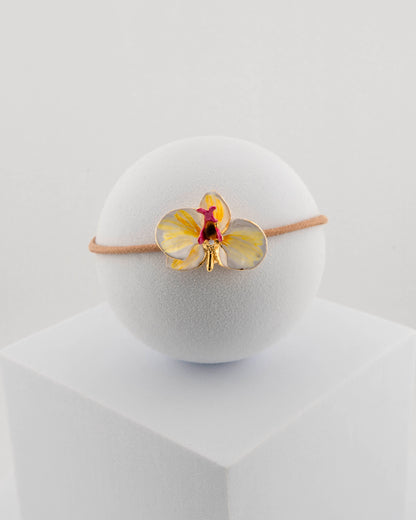 Handcrafted bracelet with adjustable cord and orchid pendant in 18K gold-plated bronze.
Each piece is hand-painted with enamel in Tuscany — unique and unrepeatable.