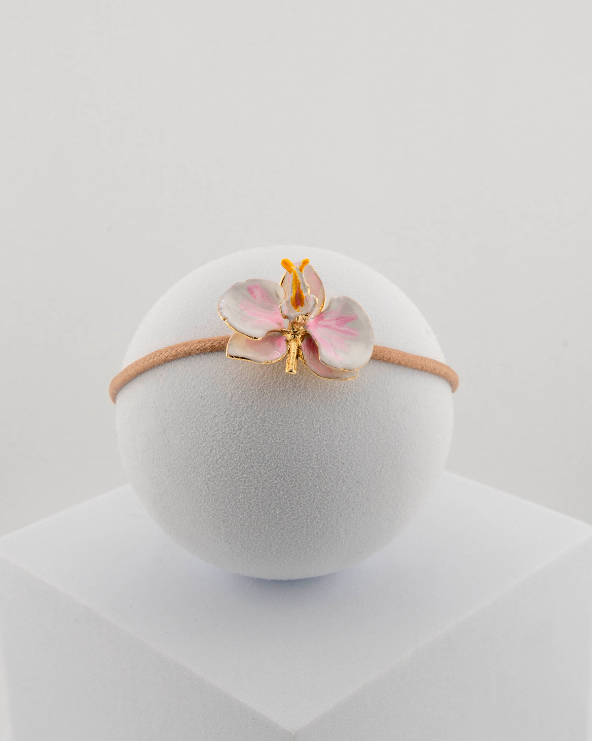 Handcrafted bracelet with adjustable cord and orchid pendant in 18K gold-plated bronze.
Each piece is hand-painted with enamel in Tuscany — unique and unrepeatable.