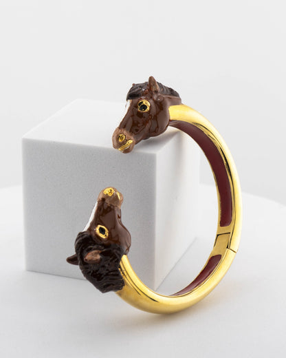 Open bracelet in white bronze with 18K gold plating and hand-painted horse heads.
An original Marri Cortona design — handmade in Tuscany.