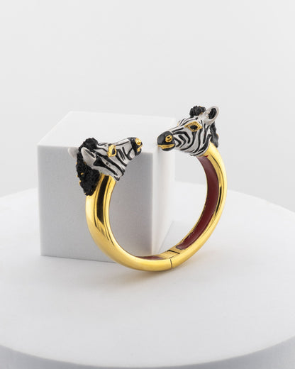 Open bracelet in white bronze with 18K gold plating, featuring hand-painted zebra heads.
An original Marri Cortona design — handmade in Tuscany.