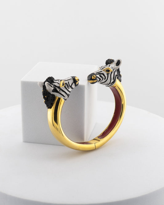 Open bracelet in white bronze with 18K gold plating, featuring hand-painted zebra heads.
An original Marri Cortona design — handmade in Tuscany.