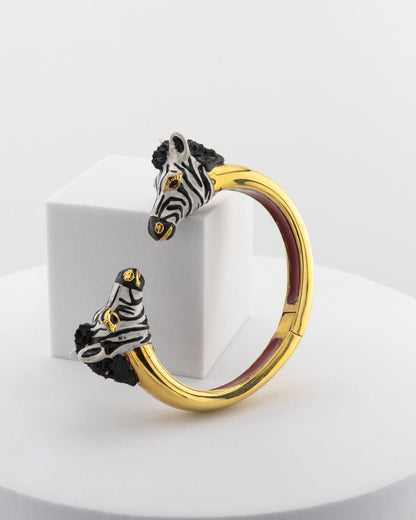 Open bracelet in white bronze with 18K gold plating, featuring hand-painted zebra heads.
An original Marri Cortona design — handmade in Tuscany.