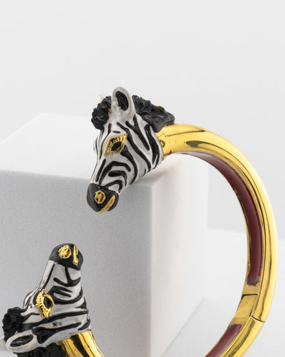 Open bracelet in white bronze with 18K gold plating, featuring hand-painted zebra heads.
An original Marri Cortona design — handmade in Tuscany.