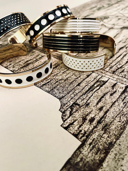 Adjustable bangle in 18K gold-plated bronze with black & white enamel.
Handcrafted in Tuscany — bold lines, timeless elegance.